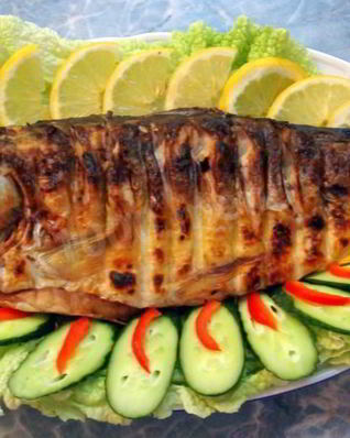 Рыба на костре на решетке на углях